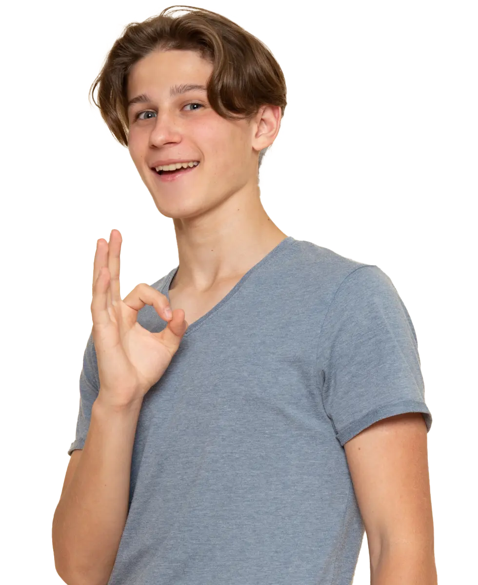 Uśmiechnięta osoba w szarej koszuli wykonująca gest „OK”.